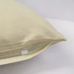 Pościel satynowa w kolorze kremowym o wymiarach 160x200, leżąca na jasnym tle. Widoczny detal zamka błyskawicznego oraz gładka, jednolita faktura materiału. Idealna do sypialni, zapewniająca komfortowy sen.