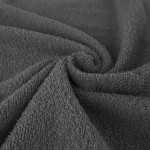 Ręcznik bawełniany Solano w kolorze ciemnego popielu, rozmiar 70x140 cm. Złożony w falę, ukazuje teksturę pętlową materiału, która zapewnia chłonność. Zdjęcie na jednolitym tle, bez dodatkowych elementów.