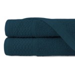 Ręcznik bawełniany 50x90 cm w ciemnym niebieskim kolorze, z widocznymi teksturowanymi paskami o wzorze rombów. Produkt leży na płaskiej powierzchni, z nałożonym na siebie drugim ręcznikiem.