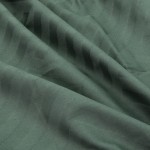 Pościel w odcieniu przygaszonej zieleni, wykonana z bawełnianej satyny żakardowej. Zbliżenie na fakturę tkaniny z subtelnym wzorem. Materiał jest gładki i lekko błyszczący, układa się w falujące plisy. Produkt darowany bez widocznych napisów i dekoracji.