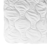 Kołdra całoroczna Antyalergiczna 200x220 w kolorze białym, rozłożona na płasko. Widoczna jest gładka faktura materiału z falistym wzorem. Produkt ma delikatne wykończenie brzegów i jest przeznaczony do używania przez cały rok.