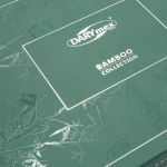 Zielone opakowanie pościeli bambusowej z białym napisem DARYmex oraz Bamboo Collection. Na powierzchni widoczne roślinne wzory. Opakowanie zamknięte, leżące na płaskiej powierzchni, z delikatnym, matowym wykończeniem.