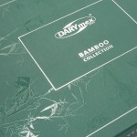 Zielone opakowanie pościeli bambusowej z białym napisem BAMBOO COLLECTION oraz logo DARYmex. Wzór na opakowaniu przedstawia delikatne liście bambusa. Opakowanie ma matową fakturę, jest prostokątne, o krawędziach w jasnym kolorze.