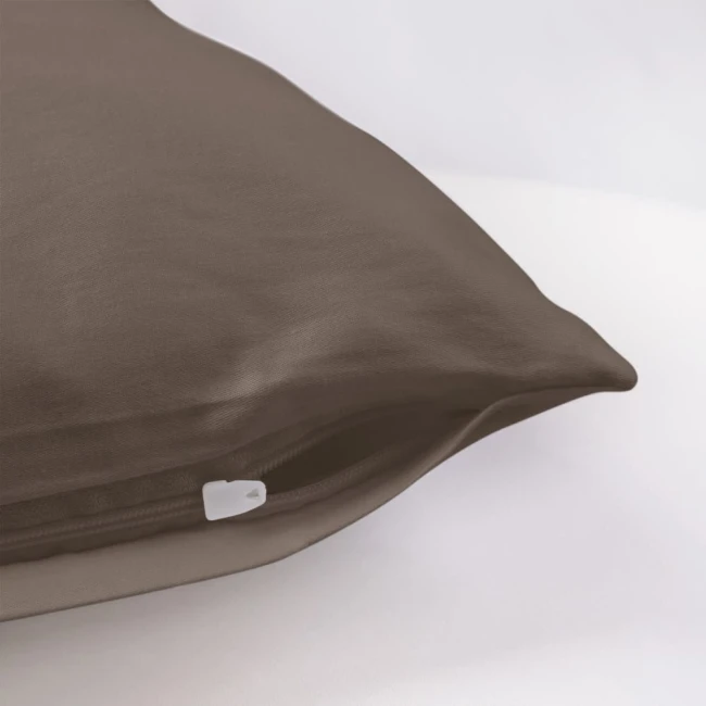 Poszewka satynowa 50x60 w kolorze sepia, leżąca na gładkim tle. Zamek błyskawiczny widoczny w dolnym rogu, faktura materiału gładka i błyszcząca. Produkt w stanie nowym, bez dodatkowych dekoracji.