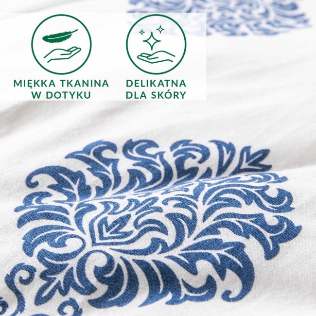 Pościel bawełniana 160x200 z niebieskim ornamentem na białym tle, eksponująca delikatny wzór roślinny. Zbliżenie na fakturę dzianiny jersey, podkreślające miękkość materiału, odpowiednie dla skóry. Grafika z symbolami wskazującymi na cechy tkaniny.