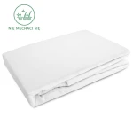 Prześcieradło flanelowe z gumką w kolorze białym, rozmiar 90x200. Produkt złożony, ukazujący miękką, teksturowaną powierzchnię. Widoczny nadruk ze wskazówką Nie mechaci się. Tło jednolite, co podkreśla jego detal.