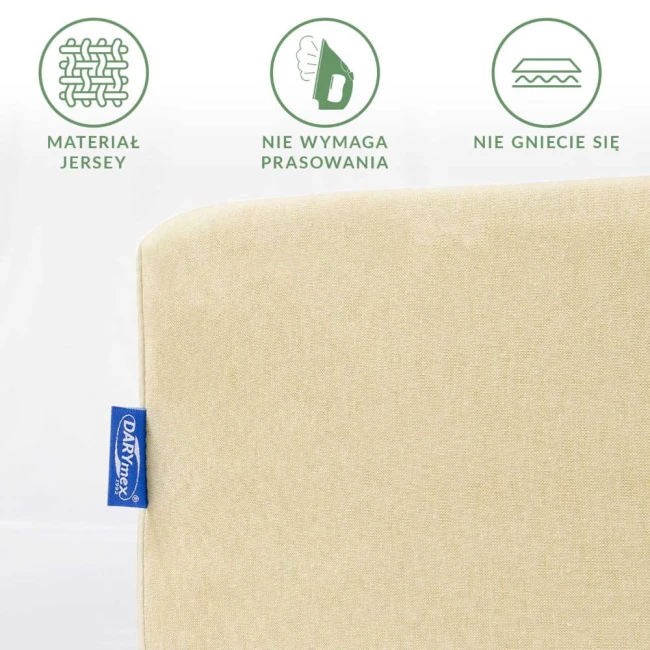 Prześcieradło jersey z gumką w kolorze kremowym, leżące, ukazujące detale materiału, nienaśnie, z wyraźnym logo producenta. Tekstura gładka, brak zagnieceń, idealne do łóżka o wymiarach 200x220. Tło jasne, jednolite.