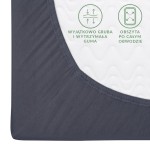 Prześcieradło jersey z gumką w kolorze antracytowym. Zbliżenie na róg, ukazujące obszerną gumę utrzymującą materiał na materacu. Widoczna faktura tkaniny z drobnymi falami, gładka powierzchnia, trwałe wykończenie.