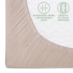Prześcieradło jersey z gumką w kolorze beżowym, rozmiar 200x220 cm. Ujęcie z boku ukazujące mocną, elastyczną gumkę z wykończeniem. Widoczna faktura materiału. Nadruk na tkaninie zawiera czytelne informacje o właściwościach produktu.