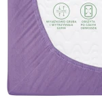 Prześcieradło jersey z gumką 140x200 w kolorze jasnego fioletu, ukazane zbliżeniem na narożnik. Materiał jest elastyczny, z widoczną także gumką obwodową. Na białym tle umieszczone są oznaczenia dotyczące grubej gumy i obwodowego obszycia.