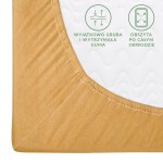 Prześcieradło jersey z gumką 140x200 w kolorze musztardowym, leżące na białym tle. Zbliżenie na róg prześcieradła ukazujące gruby brzeg z elastyczną gumą oraz widoczne napisy o właściwościach materiału. Idealne dla osób ceniących komfort snu.