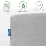 Prześcieradło jersey w kolorze popielatym o wymiarach 140x200 cm. Widoczny fragment z logo, ukazujący gładką fakturę materiału, który nie wymaga prasowania. Ujęcie frontalne, na jednolitym tle, bez dodatków.