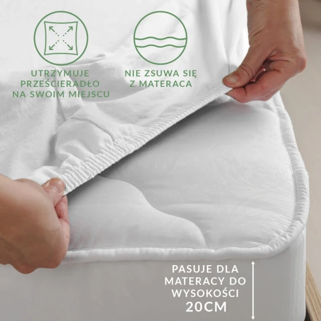 Prześcieradło jersey z gumką w kolorze białym, rozmiar 90x200 cm, z elastycznym brzegiem zapobiegającym zsuwaniu się z materaca. Ujęcie z góry, ręka chwytająca krawędź, widoczna struktura materiału. Tył na jednolitym jasnym tle.