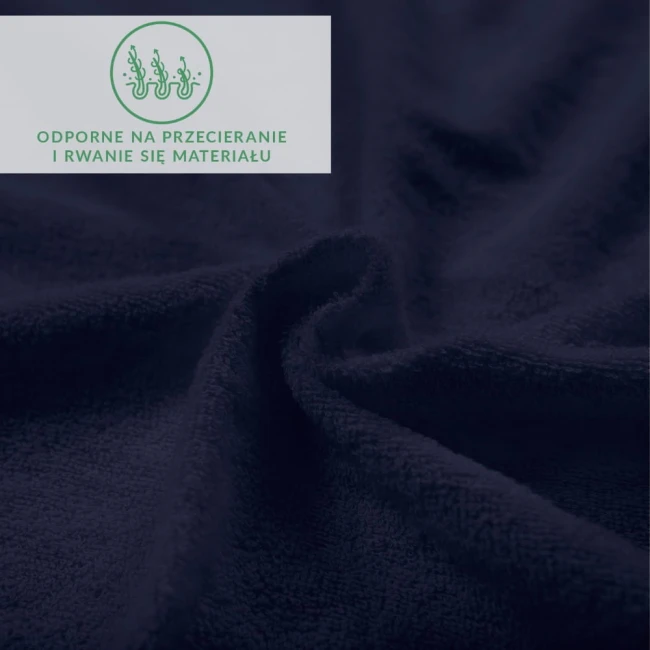 Prześcieradło frotte z gumką 90x200 w kolorze ciemnego granatu, ukazane w zbliżeniu na teksturę materiału. Zagięte i rozłożone, ukazuje miękką, odporną na przecieranie powierzchnię. W rogu widoczny napis informacyjny o właściwościach materiału.