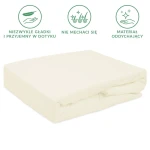 Prześcieradło frotte z gumką w kolorze ecru, rozmiar 90x200, leżące na białym tle. Materiał o delikatnej, teksturowanej powierzchni, wykazujący cechy oddychające. Gumka zapewnia solidne mocowanie na materacu, zapobiegając przesuwaniu.