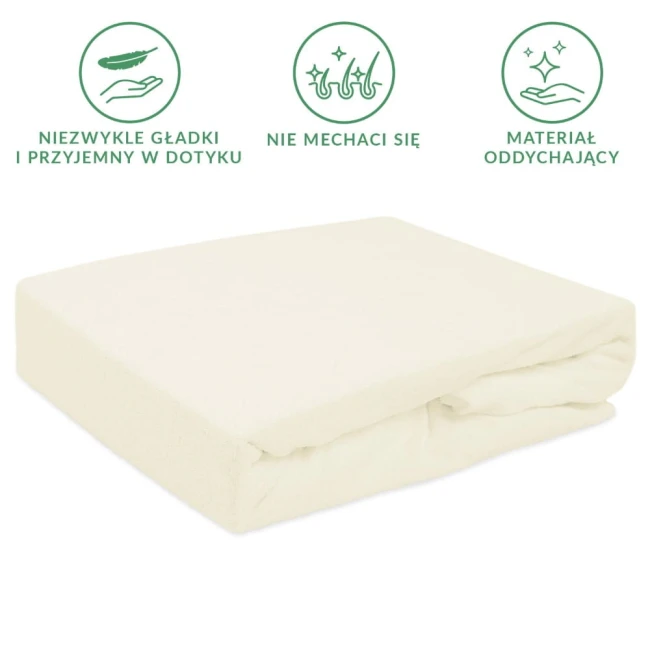 Prześcieradło frotte z gumką 140x200 w kolorze ecru, leżące w pozycji złożonej. Wykonane z miękkiego i oddychającego materiału, ma gładką fakturę. Widoczne oznaczenia dotyczące właściwości materiału, tło białe, neutralne.