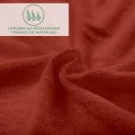 Prześcieradło frotte z gumką w kolorze bordo, zbliżenie na fakturę materiału. Wykonane z dzianiny, odporne na przecieranie. Widoczne zagięcia ukazujące miękkość i elastyczność. Ułożone w sposób luźny, tworzy naturalne fale.