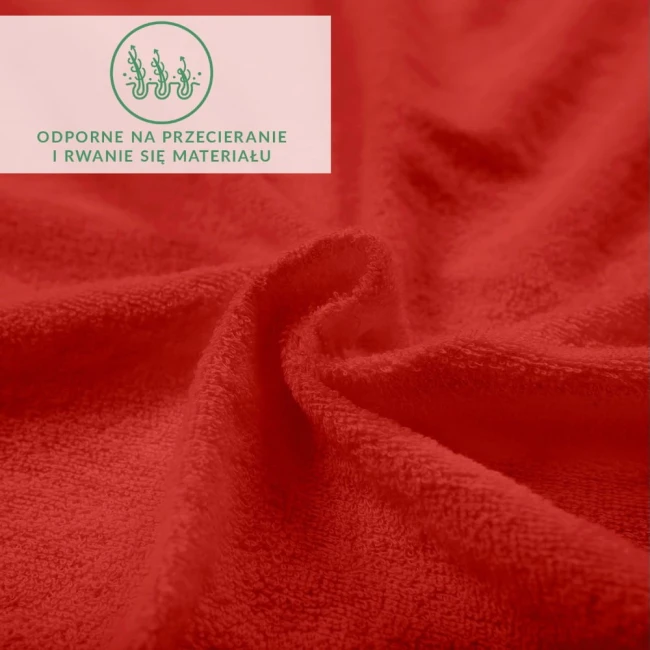 Prześcieradło frotte 160x200 w intensywnym kolorze czerwonym, o miękkiej fakturze, ukazane z bliska. Widoczne informacje na etykiecie, wskazujące odporność na przecieranie i rwanie materiału. Układ materiału w fałdach.