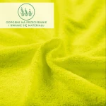 Prześcieradło frotte z gumką w kolorze limonka, wykonane z elastycznego materiału. Ułożone w zbliżeniu, ukazuje jego teksturowaną powierzchnię. Widoczne drobne detale faktury, odzwierciedlające odporność na przecieranie i rwanie.