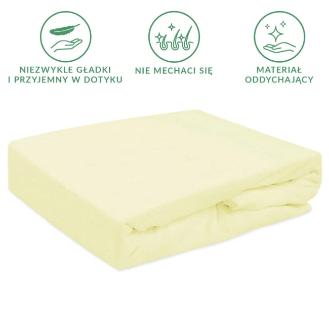 Prześcieradło frotte z gumką 180x200, kremowe, leżące na powierzchni. Materiał teksturowany, miękki w dotyku. Widoczna gumka zapewniająca stabilność. Tło jednolite, skupione na produkcie.