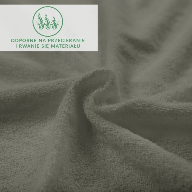 Prześcieradło frotte z gumką w kolorze szarym, wykonane z przyjemnego w dotyku materiału, prezentowane w zbliżeniu, ukazującą teksturę dzianiny. Widoczne oznaczenie dotyczące odporności na przecieranie.