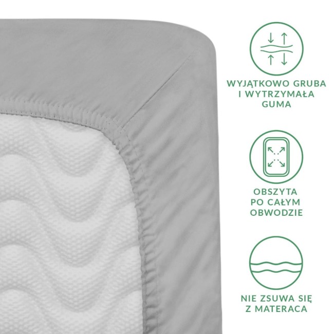 Prześcieradło satynowe z gumką 140x200 w kolorze popielatym, rozłożone na białym tle. Zbliżenie na krawędź, pokazujące grubość gumy oraz fakturę materiału. Widoczne napisy informacyjne dotyczące właściwości produktu.