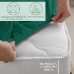 Prześcieradło jersey z elastanem w kolorze zielonym, naciągane na materac, widoczne ręka trzymająca krawędź, z gumką. Zbliżenie pokazuje elastyczność tkaniny.
