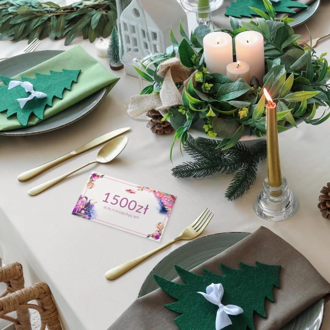 Karta podarunkowa o wartości 1500 zł, umieszczona na stole, na tle eleganckiej zastawy. Na karcie kolorowe dekoracje, szwajcarski styl graficzny.