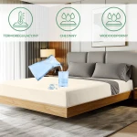 Ochronne prześcieradło z gumką 140x200 w kolorze kremowym, rozłożone na łóżku z drewnianą ramą. Woda wylewa się z szklanki, podkreślając właściwości wodoodporne.