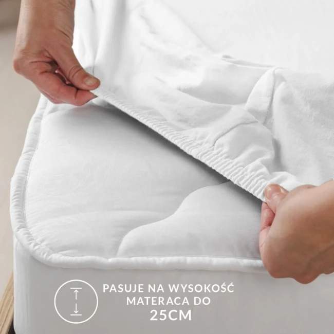 Ochronne prześcieradło z gumką 180x200 cm w kolorze jasnoróżowym, rozłożone na materacu. Zbliżenie na gumkę zabezpieczającą krawędzie, która zapewnia dopasowanie do materaca o wysokości do 25 cm. Tło białe, co podkreśla kolor prześcieradła.