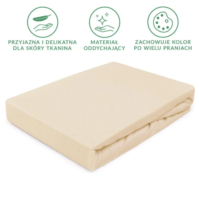 Prześcieradło jersey z gumką w jasnym beżu o wymiarach 90x200 cm, rozłożone płasko. Tkanina jest gładka z delikatną fakturą, łatwa do nałożenia na materac. Widoczne detale to estetyczne wykończenie brzegów oraz elastyczna gumka. Tło proste, białe.