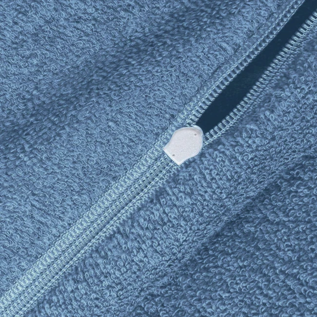 Zbliżenie na niebieską pościel frotte 160x200 z widocznym zamkiem błyskawicznym. Materiał o teksturowanej powierzchni, miły w dotyku, na jednolitym tle. Zamek umieszczony wzdłuż krawędzi, ułatwiający użytkowanie.