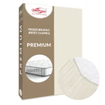 Prześcieradło jersey z gumką w kolorze ecru, w opakowaniu PREMIUM. Na zdjęciu widoczny detal gumki oraz faktura materiału. Zbliżenie na róg prześcieradła w celu podkreślenia jego elastyczności i dopasowania do materaca o wysokości 25 cm.