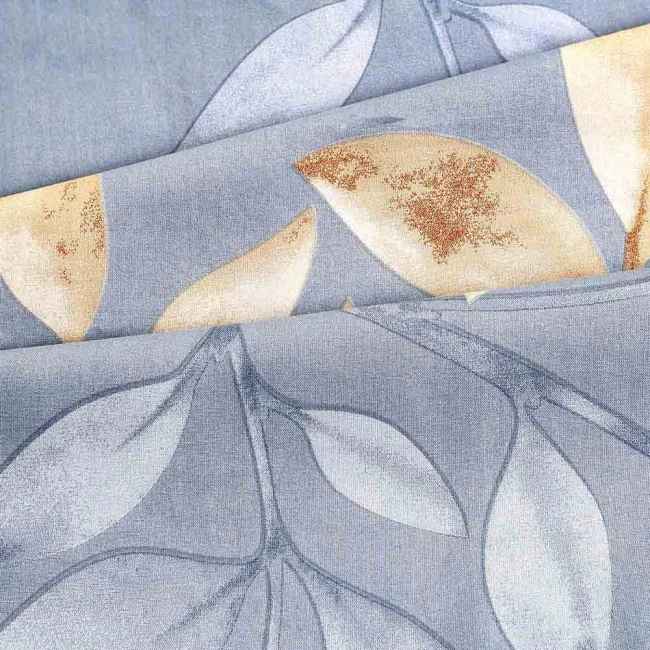 Pościel bawełniana 220x200 Sandleaf w odcieniach niebieskiego z beżowymi liśćmi, wykonana z miękkiego materiału. Widoczny wzór liści w różnych rozmiarach na gładkim tle. Ułożona w lekkich fałdach, podkreślająca teksturę materiału.
