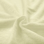Pościel frotte 155x220 w kolorze kremowym, o miękkiej, teksturowanej powierzchni. Ułożona w falisty sposób, ukazująca delikatny splot materiału, idealna do eleganckich aranżacji sypialni.