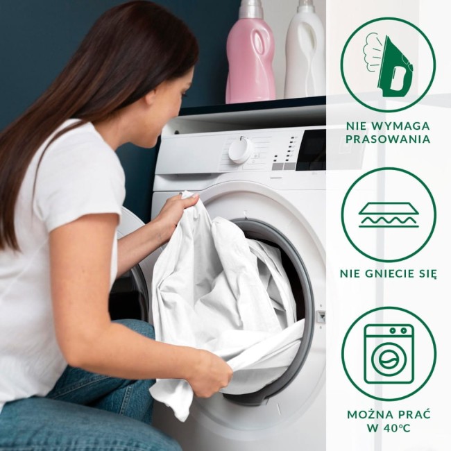 Kobieta w białej koszulce umieszcza białą pościel w pralce. Pralnica z panelami sterującymi jest widoczna z przodu. Na zdjęciu znajdują się również ikony informacyjne o łatwej pielęgnacji pościeli: nie wymaga prasowania oraz można prać w 40°C.